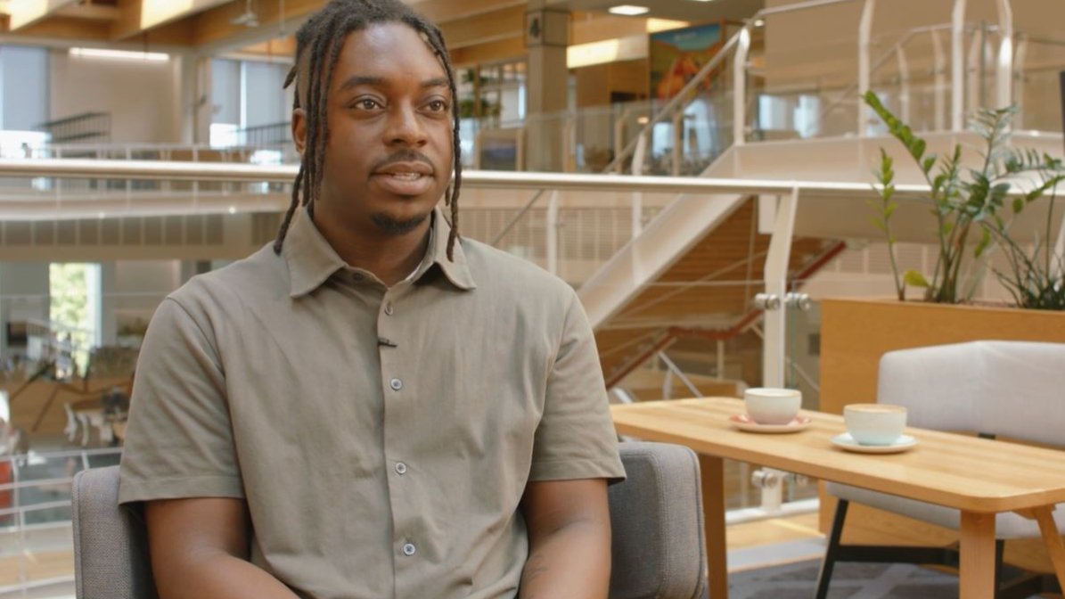 A photo of Liam Bradshaw-Shallow, Early Careers Attraction Coordinator at Sky, sat in the Sky Campus building