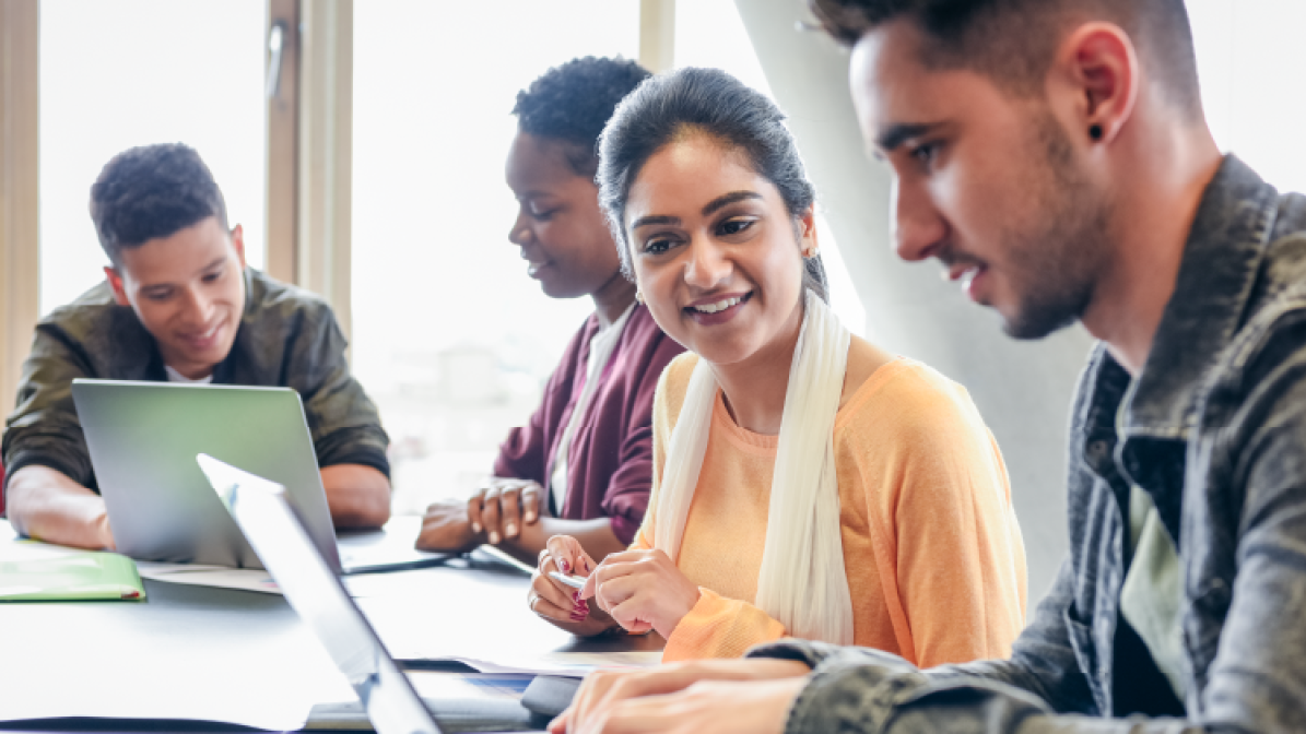 A photo of a group of students sitting working at their laptops