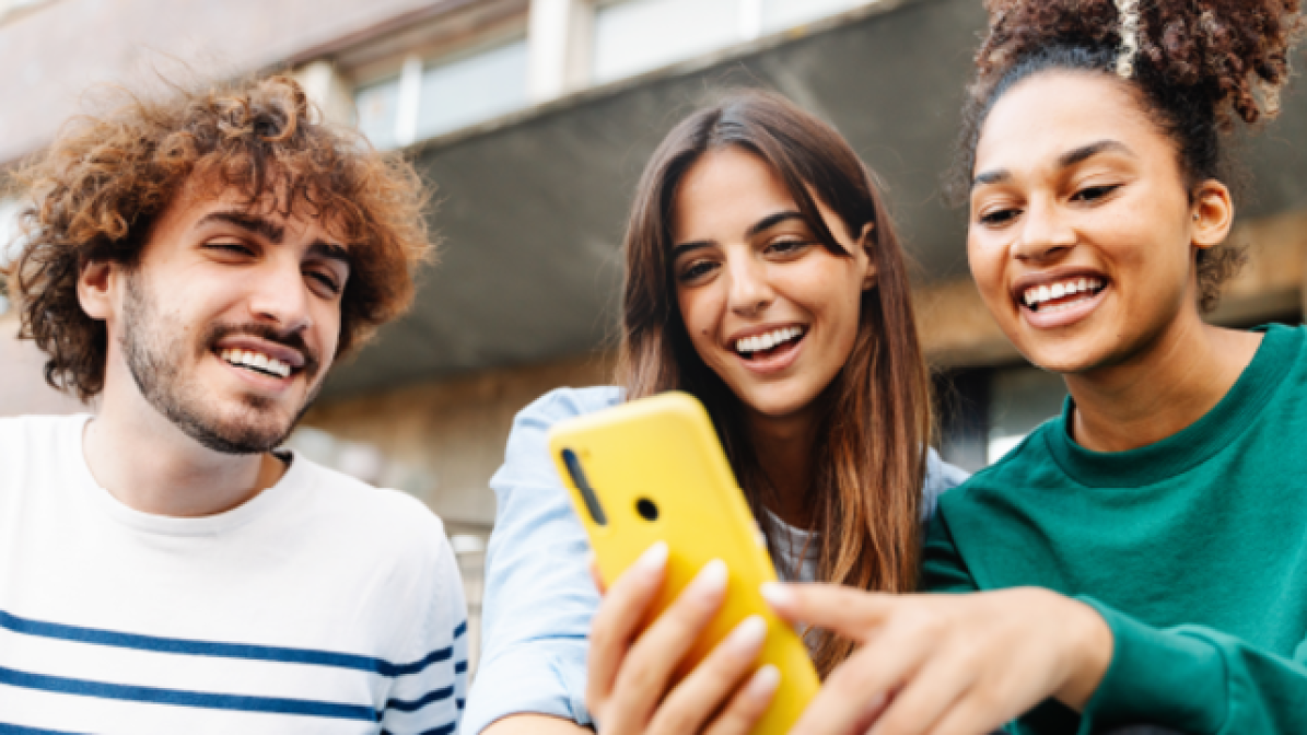 Three students looking at mobile phone