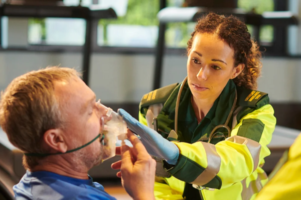 Paramedic giving oxygen to patient