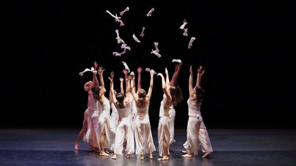 Group of dancers on stage throwing gloves in the air 