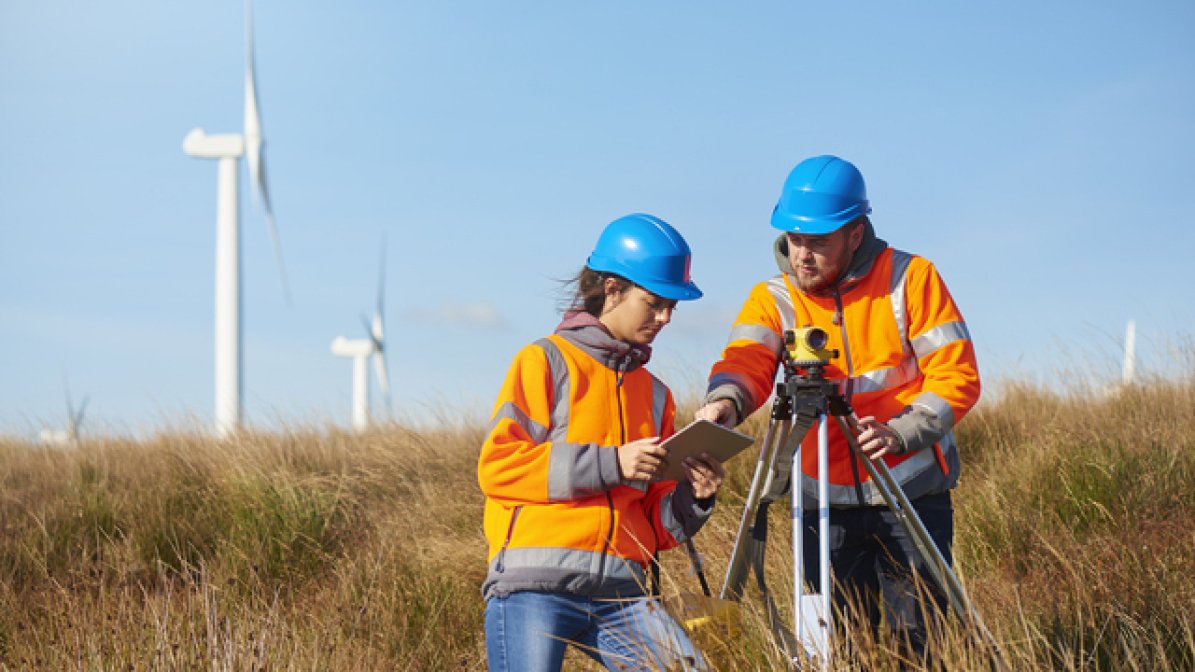 Two quantity surveyors working in a field 