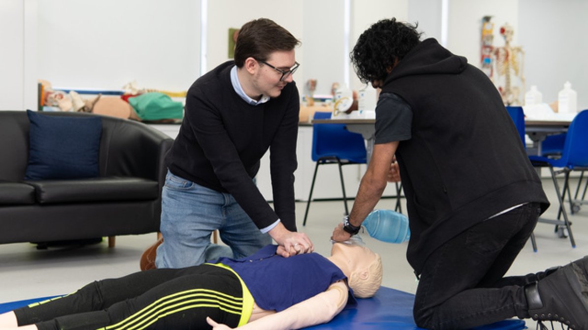 Paramedic science students performing CPR on a dummy patient