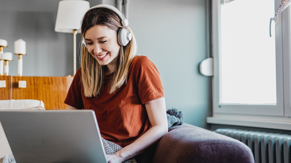 Young woman with headphones on laptop